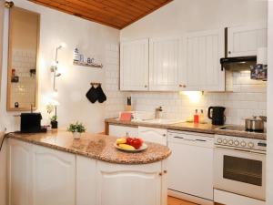 eine Küche mit weißen Schränken und einer Obstschale auf der Theke in der Unterkunft Holiday Home Le Mas Saphir by Interhome in Bouveret