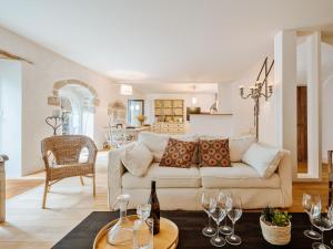 ein Wohnzimmer mit einem Sofa und einem Tisch mit Weingläsern in der Unterkunft Villa Scarlette by Interhome in Saint-Briac-sur-Mer