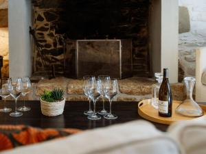 a group of wine glasses on a table with a fireplace at Villa Scarlette by Interhome in Saint-Briac-sur-Mer