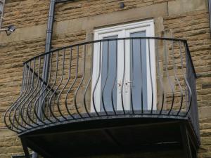 a balcony on the side of a building with a window at Hunter's Lodge in Buxton