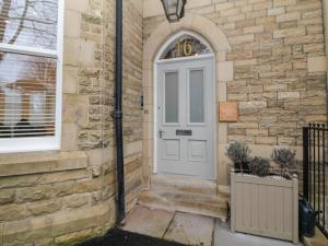una puerta blanca en una casa de ladrillo con una ventana en Hunter's Lodge, en Buxton