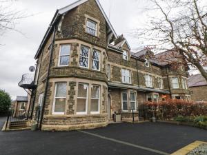 un gran edificio de ladrillo con ventanas blancas. en Hunter's Lodge, en Buxton