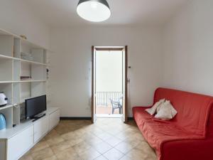 ein Wohnzimmer mit einem roten Sofa und einem TV in der Unterkunft Apartment Alice 3 by Interhome in Riva Ligure