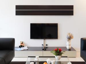 a living room with a tv on the wall at Apartment Les Terrasses C1-7 by Interhome in Montreux