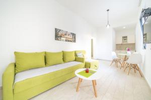 uma sala de estar com um sofá verde e uma mesa em Mariner Apartments em Sutomore