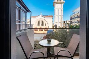 a balcony with a table and chairs and a clock tower at Al Centro Zante city flat in Zakynthos