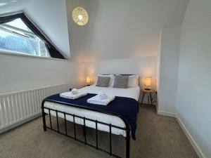 a bedroom with a bed with two towels on it at School Path Ironbridge Home with Roof Terrace in Ironbridge