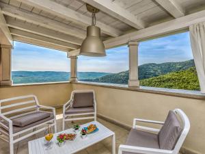 balcone con sedie, tavolo e vista di Villa Villa Over the Hilltop by Interhome a Bencani