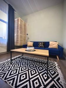 a blue couch in a living room with a rug at ALTiDude in Cluj-Napoca