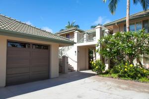 a house with a garage and a palm tree at Wai'ula'ula D201 in Hapuna Beach