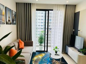 ein Wohnzimmer mit Sofa und Fernseher in der Unterkunft Vinhomes Grand Park Quận 9-Luxury Apartment-Plus 2PN in Long Bình