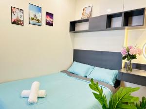 ein Schlafzimmer mit einem blauen Bett und einem Regal in der Unterkunft Vinhomes Grand Park Quận 9-Luxury Apartment-Plus 2PN in Long Bình + 22 Fotos