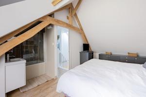 1 dormitorio con cama blanca y ventana en Maison avec Terrasse - 2 chambres confortables pour 4 à 6 personnes, en Verton