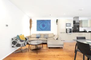 uma sala de estar com um sofá e uma mesa em Loft-style 3 bed apartment in Hoxton London! em Londres