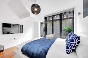 um quarto com uma cama grande e uma janela grande em Loft-style 3 bed apartment in Hoxton London! em Londres