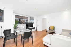uma sala de estar com um sofá branco e uma mesa em Loft-style 3 bed apartment in Hoxton London! em Londres