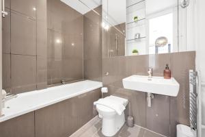 uma casa de banho com um WC, um lavatório e uma banheira em Loft-style 3 bed apartment in Hoxton London! em Londres