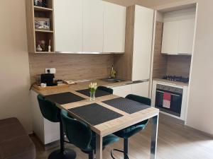 a kitchen with a table with green chairs in a room at B&B Nadia House in Bisceglie