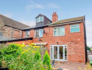 a red brick house with a window at Modern flat with garden in city centre in Hereford