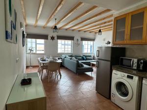 a kitchen and living room with a couch and a table at Porto Covo / Costa Alentejana in Porto Covo