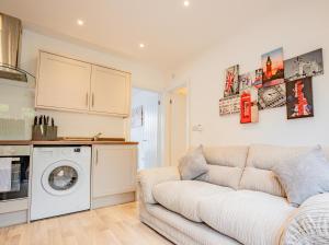 a living room with a couch and a washing machine at Modern flat with garden in city centre in Hereford