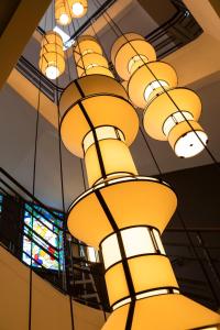 a group of yellow lights hanging from a ceiling at Oceania Le Conti in Brest