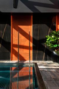 a pool with an orange wall and a plant at Oceania Le Conti in Brest
