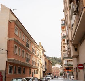 una calle de la ciudad con coches estacionados al lado de los edificios en Stay U-nique Apartment Fernando Católico, en Málaga