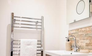 a bathroom with a towel rack over the sink at Modern flat with garden in city centre in Hereford