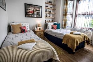 ein Schlafzimmer mit zwei Betten und einem Fenster in der Unterkunft Johaan in Caernarfon