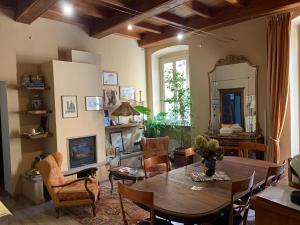 a living room with a table and chairs and a fireplace at Domus Aurea in Saluzzo