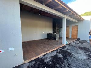 un garaje vacío con un gran patio fuera de una casa en Quintal en Capitão Leônidas Marques
