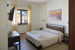 a bedroom with a bed and a desk and a television at Casa via Pascoli in Arzachena
