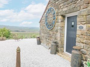 a stone building with a door and a window at Curlew Cottage in Warslow