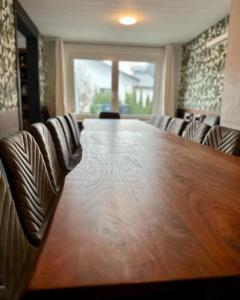 una sala de conferencias con una gran mesa de madera y sillas en Ferienhaus Winterberg Lodge en Winterberg