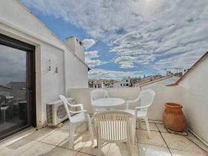 a patio with a table and chairs on a balcony at Plage, centre ville, terrasse in Saintes-Maries-de-la-Mer