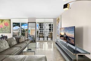 sala de estar con sofá y TV de pantalla grande en King David Dream Home en Miami Beach
