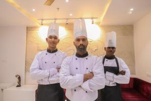 three chefs standing in a kitchen with their arms crossed at The RRA Kabras Hotel, Nathdwara in Nāthdwāra
