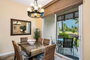 - une salle à manger avec une table, des chaises et un miroir dans l'établissement Colony Villas at Waikoloa Beach Resort #204, à Waikoloa