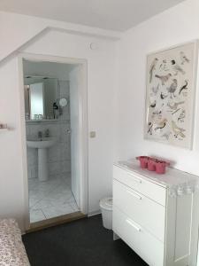 a white bathroom with a toilet and a sink at Ferienwohnung Mandelblüte in Schotten