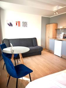 salon z kanapą, stołem i krzesłami w obiekcie 3 Budget Stay Apartments w mieście Zgorzelec
