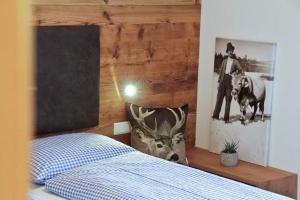 1 dormitorio con 1 cama con una foto en la pared en Jaiterhof Apartment Furchetta, en Villnoss