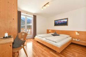 1 dormitorio con cama, escritorio y ventana en Jaiterhof Apartment Reinhold Messner, en Villnoss
