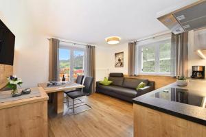 cocina y sala de estar con sofá y mesa en Jaiterhof Apartment Reinhold Messner, en Villnoss