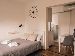 a bedroom with a bed and a clock on the wall at Studio apartmani Venium in Križevci