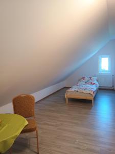 a bedroom with a bed and a chair and a table at Agroturystyka U Puchatka in Rebiszów