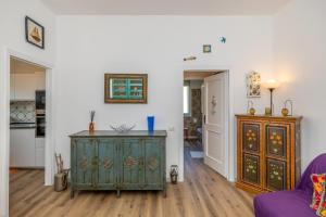 ein Wohnzimmer mit einem grünen Schrank und einer Küche in der Unterkunft G&G in Finale Ligure