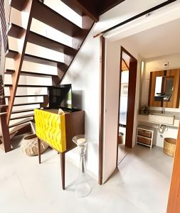 sala de estar con escalera y caja amarilla en Refúgio paradisíaco em búzios., en Búzios