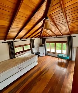 1 dormitorio en una casa con cama y techos de madera en Refúgio paradisíaco em búzios., en Búzios
