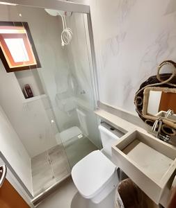 a bathroom with a toilet and a sink at Refúgio paradisíaco em búzios. in Búzios